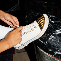 Das Modehaus Schiaparelli hat Sneakers mit Socken in Form von goldenen Zehen herausgebracht